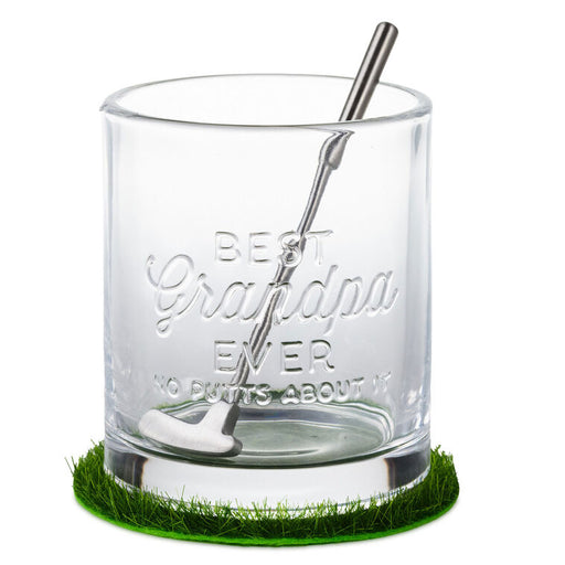 Clear glass tumbler with engraved text and golf club on a grassy base