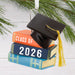 Graduation-themed ornament with books and cap, featuring 'Class of 2026'.