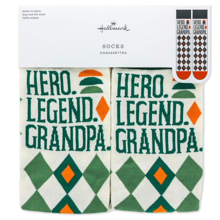 Pair of socks with 'Hero. Legend. Grandpa.' text and geometric patterns, displayed in packaging with Hallmark branding.
