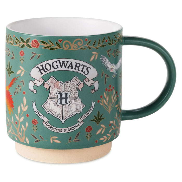 A teal ceramic mug featuring the Hogwarts crest and floral illustrations, with a dark green handle and interior, set against a plain white background.