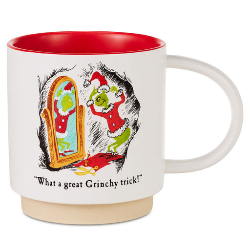 A white ceramic mug with a red interior and a beige base, featuring a Grinch-themed illustration of the Grinch looking at his reflection in a mirror with the text 'What a great Grinchy trick!'.