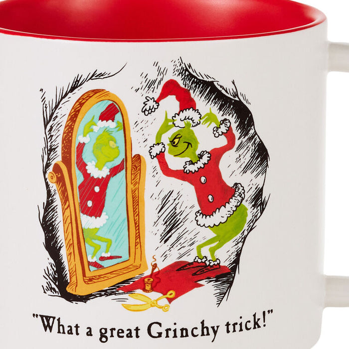 A white ceramic mug with a red interior, featuring a Grinch-themed illustration of the Grinch looking at his mirror in a Santa suit and the text 'What a great Grinchy trick!'.