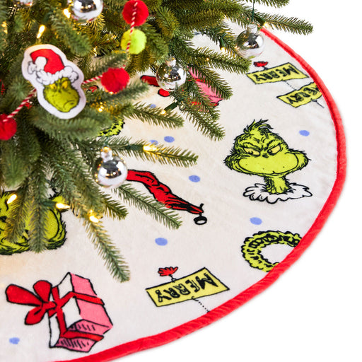 Christmas tree skirt with Grinch design around a decorated Christmas tree.