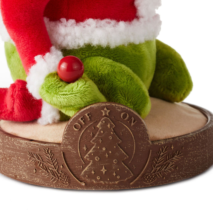 Close-up of a Christmas-themed toy with a wooden base and 'Off On' switch.