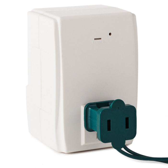 White wall outlet with a green plug on a white background