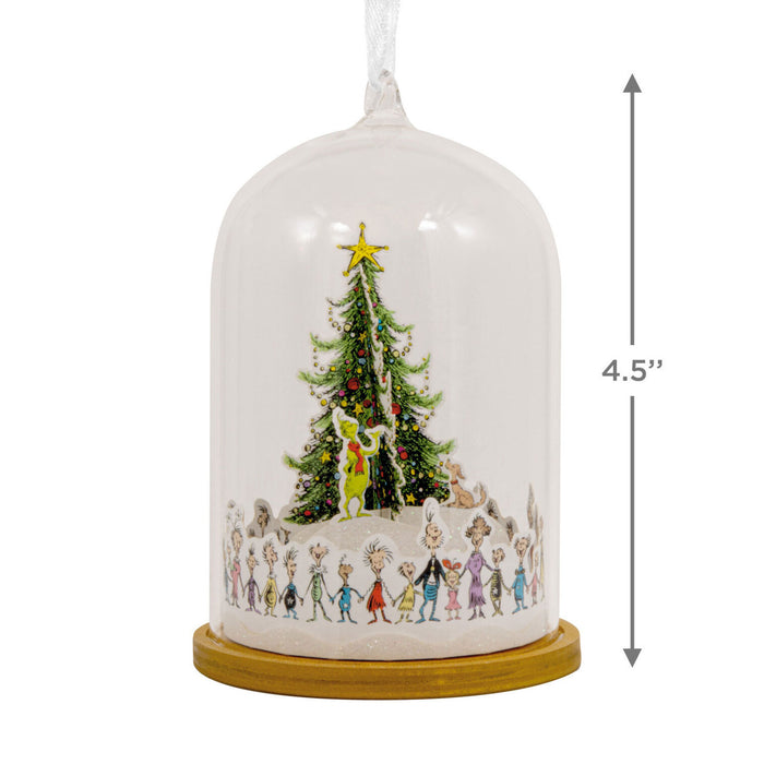 Decorative Christmas scene under a glass dome with a star on top, featuring cartoon characters around a Christmas tree.