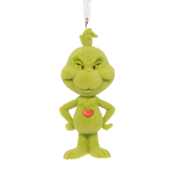A green Grinch plush ornament with yellow eyes, a red heart on the chest, and a white hanging loop at the top, shown against a plain white background.