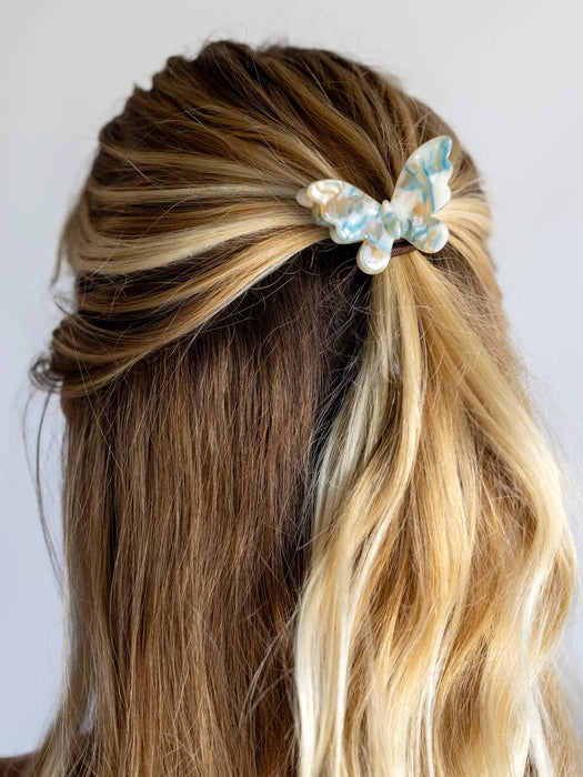 Hair with a decorative bow accessory on a plain background