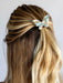 Hair with a decorative bow accessory on a plain background