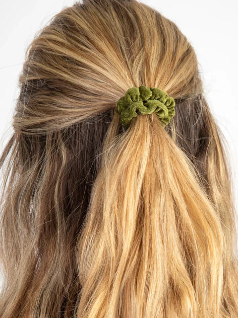 Green hair tie holding a ponytail with blonde hair on a white background