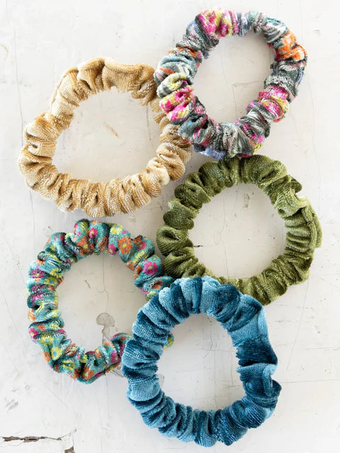 Five colorful scrunchies on a white background