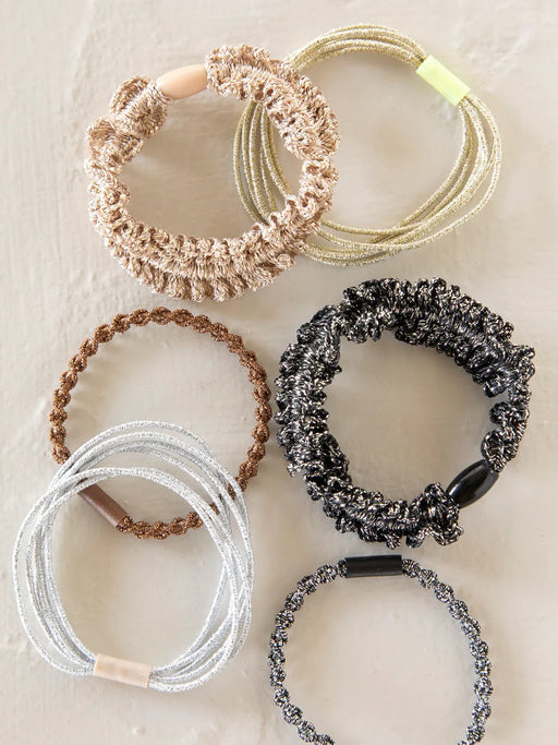 Set of six hair ties in various colors on a textured surface
