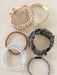 Set of six hair ties in various colors on a textured surface