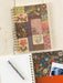Notebook with colorful floral and text pattern on a wooden surface