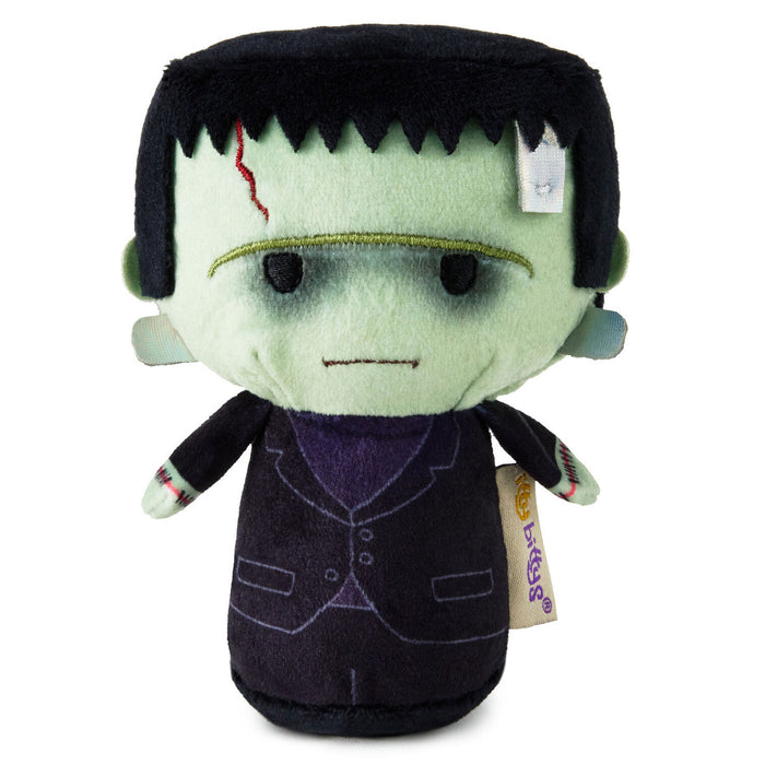 A plush toy of Frankenstein's monster with light green skin, black hair, a black suit, and a purple vest, shown on a white background.