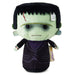 A plush toy of Frankenstein's monster with light green skin, black hair, a black suit, and a purple vest, shown on a white background.