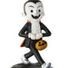 A cartoon-style vampire figurine wearing a black tuxedo with an orange cape, holding a jack-o'-lantern bucket, shown on a plain white background.