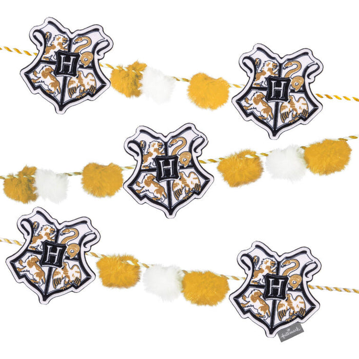 Decorative banner with Hogwarts crest and pom-poms on a white background