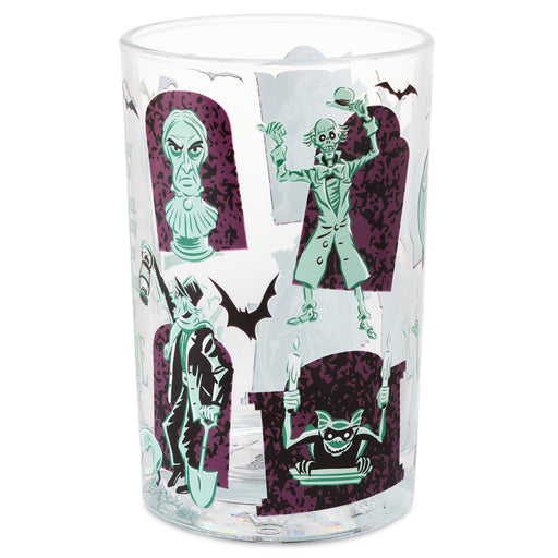 A clear glass tumbler featuring a Halloween-themed graphic print with green and purple tombstone illustrations, bat silhouettes, and spooky character designs on a white background.
