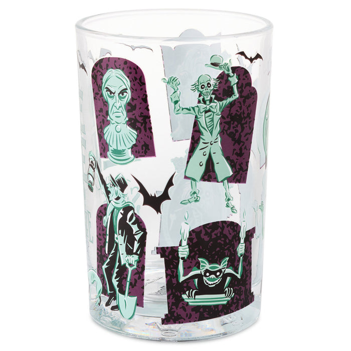 A clear glass tumbler featuring a Halloween-themed graphic print with green and purple tombstone illustrations, bat silhouettes, and spooky character designs on a white background.