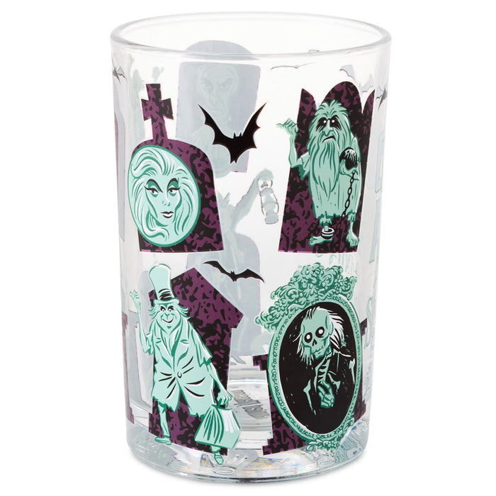 A clear glass tumbler featuring a Halloween-themed print with green and purple illustrations of classic horror characters, tombstones, bats, and a ghostly figure, shown on a plain white background.
