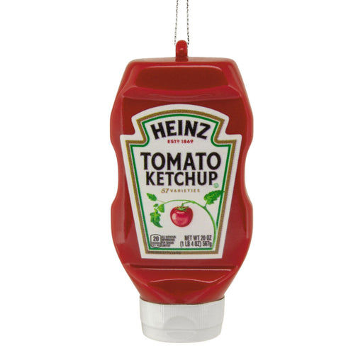 A red Heinz Tomato Ketchup squeeze bottle ornament or decoration with a white cap and a hanging loop at the top, shown on a plain white background.
