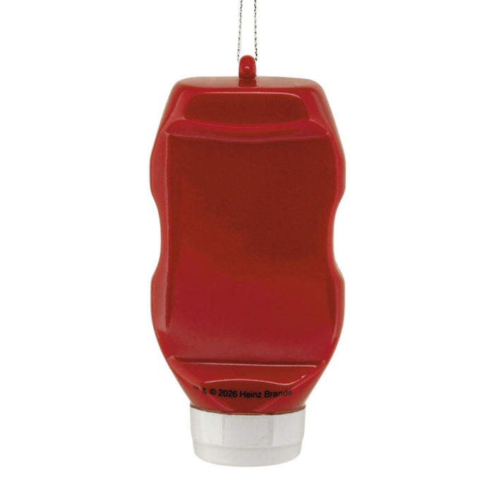 A red ketchup bottle ornament with a clear plastic cap and a hanging loop at the top, shown against a plain white background.