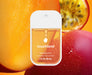 Touchland hand sanitizer bottle with a fruit-themed background