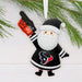 A festive Christmas ornament shaped like a Santa Claus figure in a Houston Texans jersey, holding a foam finger that says 'GO TEXANS'. The ornament hangs from a white ribbon against a white wood background with pine branches at the top.