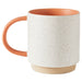 Speckled ceramic mug with terracotta handle and rim on a white background