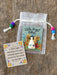 Little Angel token with a card on a wooden surface