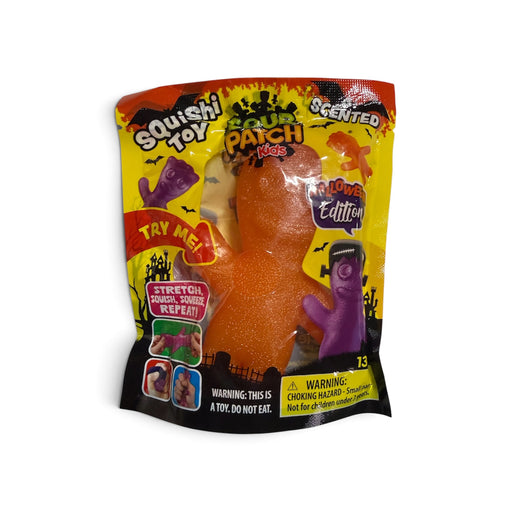A packaged 'Scary Patch Kids' squishy toy in a 'Lower Edition' scented variety. The toy is a glittery orange monster with a clear window showing the product inside, alongside a purple zombie figure.
