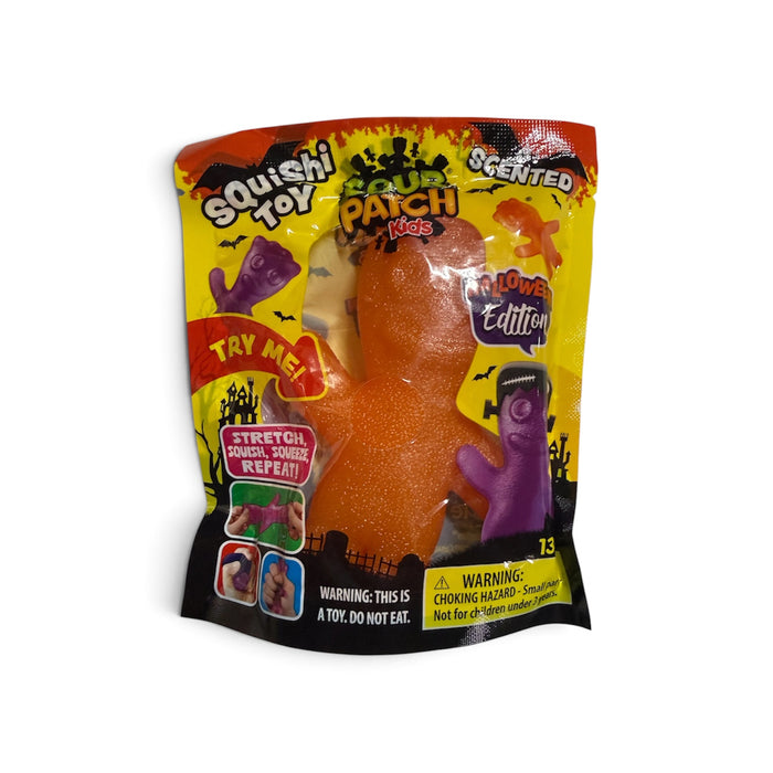A packaged 'Scary Patch Kids' squishy toy in a 'Lower Edition' scented variety. The toy is a glittery orange monster with a clear window showing the product inside, alongside a purple zombie figure.