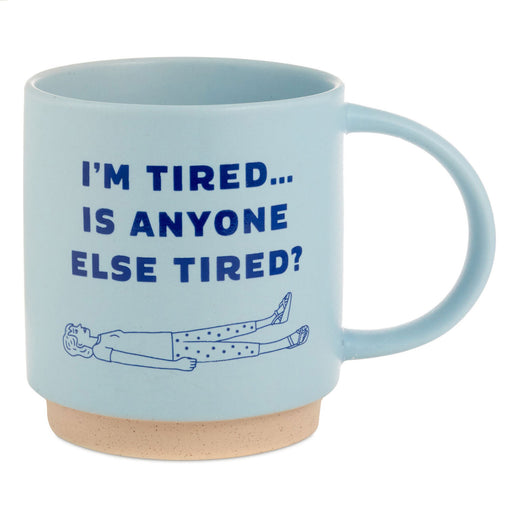 Light blue mug with text 'I'm Tired... Is Anyone Else Tired?' and a sleeping person illustration on a white background.