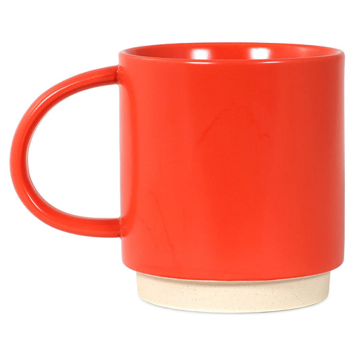 Red ceramic mug with a wooden base on a white background