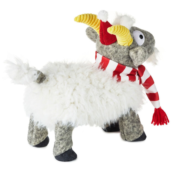 Plush toy resembling a sheep with a red scarf and yellow horn-like feature on a white background