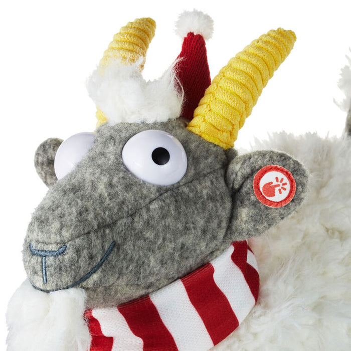 Plush toy with yellow horns, red scarf, and gray body on a white background