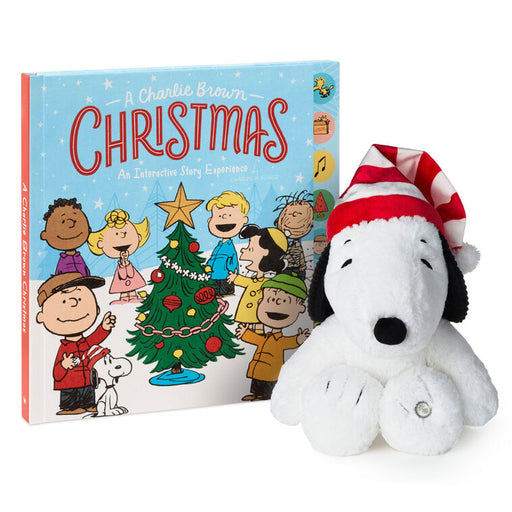 Peanuts-themed Christmas book with characters and a Snoopy plush toy wearing a Santa hat.