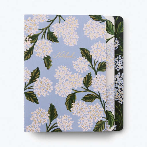 Floral notebook with white flowers and green leaves on a light blue background