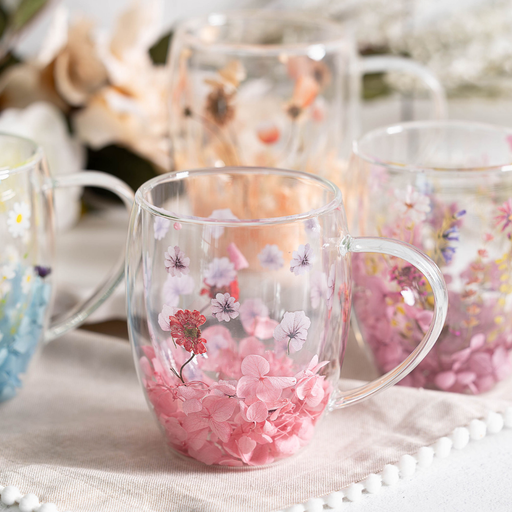Clear glass mugs with floral designs on a light background