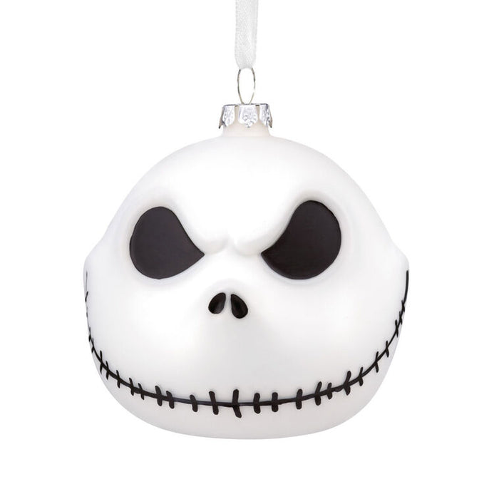 White ornament with black eye sockets and mouth on a white background