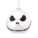 White ornament with black eye sockets and mouth on a white background