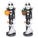 Two Jack Skellington and Sally nutcracker figurines from Disney's The Nightmare Before Christmas, shown side by side on a white background. The left figure holds a carved jack-o'-lantern, and the right figure holds a red Christmas gift with green wrapping paper.