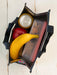 Reusable shopping bag with a banana, apple, and snack container on a wooden surface