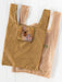 A reusable plastic shopping bag with a brown and beige gingham pattern, featuring a front pocket with a colorful dog patchwork design, shown alongside a clear plastic bag on a white wooden background.