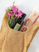 Yellow checkered apron with a bouquet of pink flowers, bottle of olive oil, and box of Spaghetti.