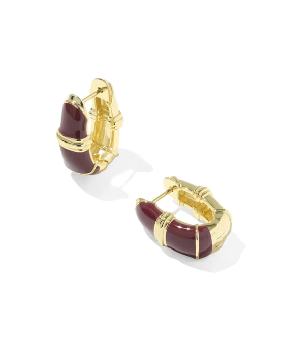 A pair of gold huggie hoop earrings with curved dark red enamel inlays, shown on a clean white background.