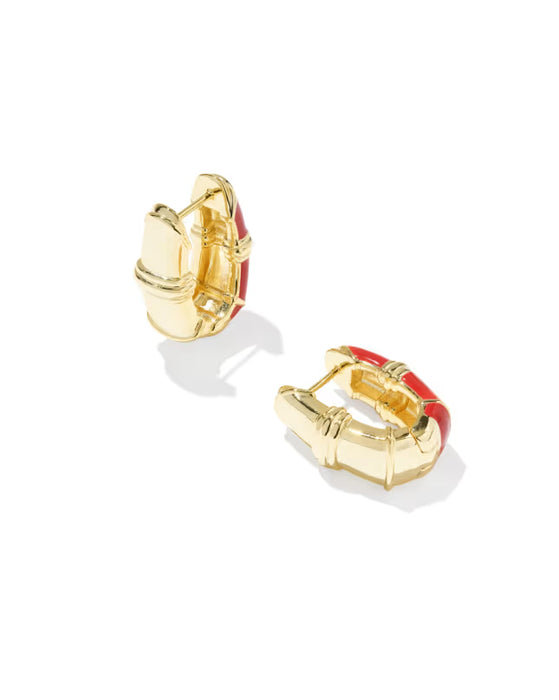 A pair of gold huggie hoop earrings with red enamel accents, displayed on a clean white background.
