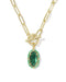 A gold paperclip chain necklace with a toggle clasp and a green emerald-cut pendant, shown on a clean white background.