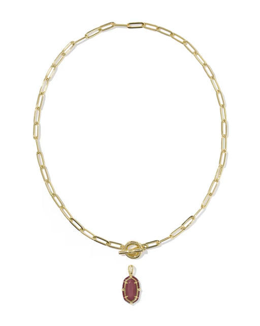 A gold paperclip chain necklace with a toggle clasp and a small oval maroon gemstone pendant, shown on a plain white background.